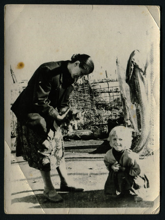 Ussr - CIRCA 1970s: An antique Black & White photo show Mom and daughter in the courtyardのeditorial素材
