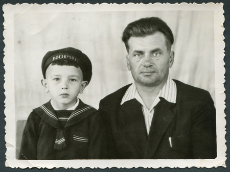 Ussr - CIRCA 1970s: An antique Black & White photo show studio portrait Man and his son.のeditorial素材