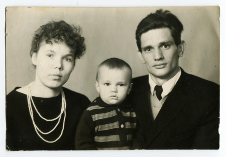 Ussr - CIRCA 1980s: An antique Black & White photo shows Family portrait of a young couple with a child, an old pictureのeditorial素材