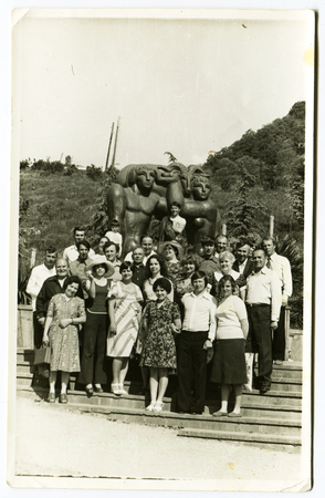 Ussr - CIRCA 1980s: An antique Black & White photo show a group of tourists on a background of sculptureのeditorial素材