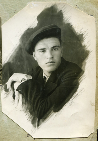 Ussr - CIRCA 1940s: An antique Black & White photo show portrait of a young guy wearing a cap