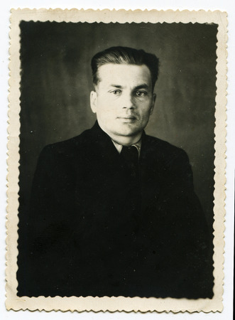 Ussr - CIRCA 1940s: An antique Black & White photo show a man in a raincoatのeditorial素材