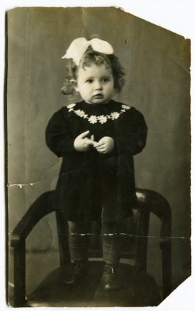 USSR - CIRCA 1940s: An antique photo shows little girl on a chair, USSR, circa 1940sのeditorial素材