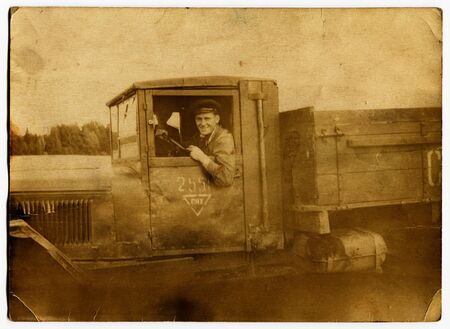USSR - CIRCA 1940s: An antique photo show man driving a military truckのeditorial素材