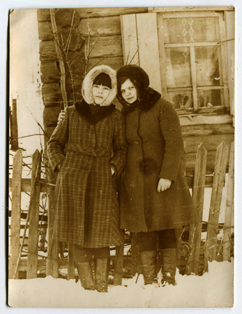 USSR - CIRCA 1960s: An antique photo shows  two village girls standing near the fence, USSR, circa 1960sのeditorial素材