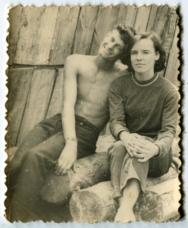 Ussr - CIRCA 1970s: An antique Black & White photo show man and woman sitting on logsのeditorial素材
