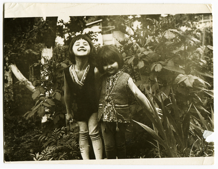 Ussr - CIRCA 1970s: An antique Black & White photo show two little beautiful girls in the gardenのeditorial素材
