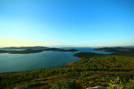 Seascape and islands. Green herbs. Photographed from the hill during sunset. Blue sky.の写真素材