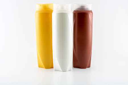 Shampoo, moisturizing bottles in brown, white, yellow colors. Shooting in white background.の写真素材
