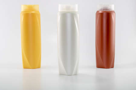 Shampoo, moisturizing bottles in brown, white, yellow colors. Shooting in white background.の写真素材