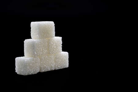 Sugar cubes lined up in pyramid shape. Black backgroundの写真素材