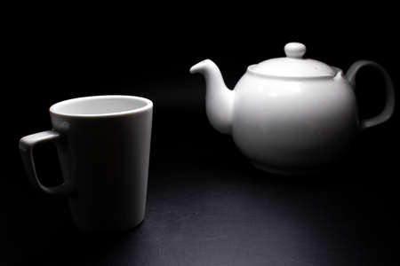White porcelain teapot and cups. Traditional design. Black background.の写真素材