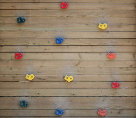 Wooden climbing wall. Colorful plastic parts. For kids.Child climbing warning sign in park.の写真素材