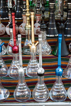 Traditional hookah machines. Stands on the shelf in different colors and patterns. Photographed in...