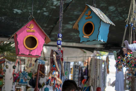 Birdhouse and bird ornament hanging on chain.の写真素材