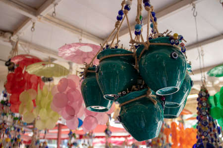 Flower pots in blue color. Pots in rope and evil eye beads. Blurred background. Taken inside the...