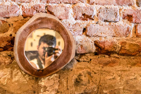 Mirror with wooden frame. Old brick wall in the background.の写真素材