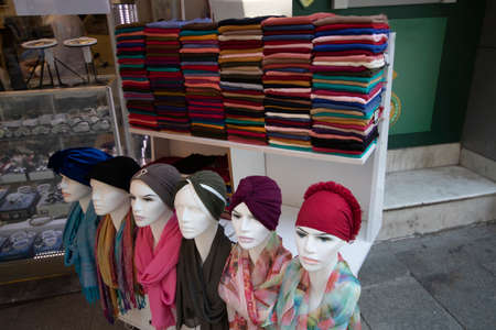 Shawls of different designs and colors to cover the head. It was taken in front of the store. On lifeless mannequins.の写真素材