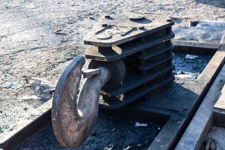 Old heavy duty hook standing on the ground.