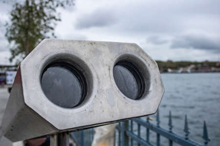 Close-up of the front side of the binoculars. There are two optical glass. Seascape in the background.の写真素材