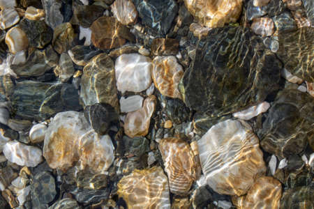 Round stones close-up in the water. Etching of waterの写真素材