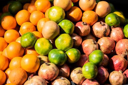 tangerines pomegranate and orange heap close-up. On the light of day.の写真素材