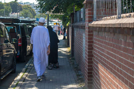 Eminonu, Istanbul, Turkey - July 29, 2019: Muslim family with local clothes walking on the road. Black and white local costumes.のeditorial素材