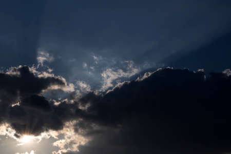 In the evening, sunlight is radiating through the clouds.の写真素材