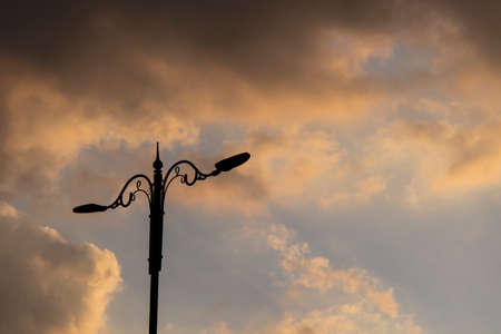 A streetlight on the left and cloudy skies in the background. It was taken at sunset.