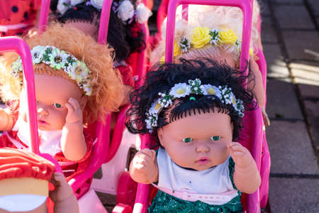 Colorful eyed baby with plastic hair sold outside in front of store for girls.の写真素材