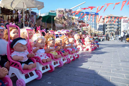 Colorful eyed baby with plastic hair sold outside in front of store for girls.の写真素材
