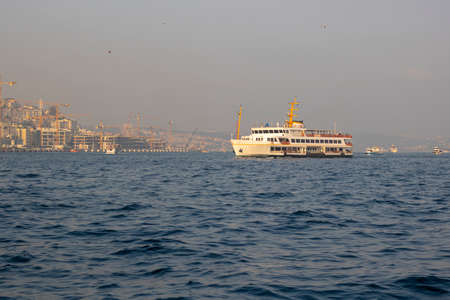 Steamship photographed during sunset at the sea in the Bosphorus. Behind the ship is the city of Istanbul.の写真素材