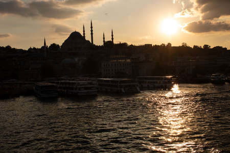 Suleymaniye Mosque and Eminonu coast in cloudy weather. Boats selling fried fish and people walking around. Photographed towards the evening.のeditorial素材
