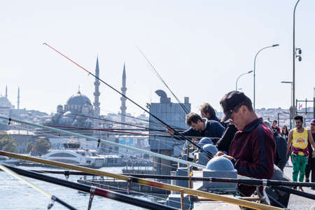 Fishermen and tourists are on the Galata Bridge in Istanbul, Turkey. It is a famous landmark of Istanbul. Galata Bridge with lot of people in historical center of Istanbul.のeditorial素材