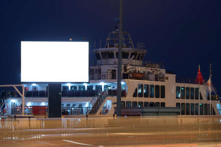 Advertising sign is blank white. Long exposure across the road. There is a ferry in the back.の写真素材