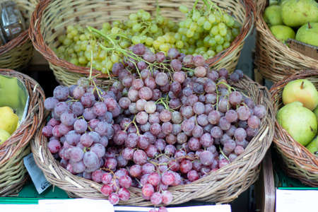 Fruit grape on the greengrocer counter. Bench on the pavement. The photo was taken from the side.