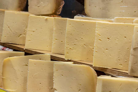 Close-up of cheddar cheese is sold in the market. Triangular slice shaped. It is produced in Turkey.