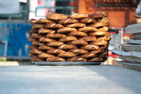 Bagel bench on the table. A lot of bagels are lined up regularly. It is sold by a street vendor....