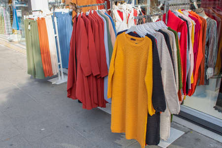 Clothes with different patterns and varieties hanging in front of the store. The photo was taken outside.の写真素材