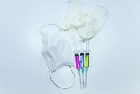3 different colors liquid and mouth mask, gloves in the syringe. Photographed in the studio and...