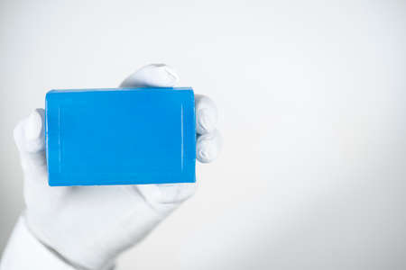 Soap for personal cleaning against viruses and bacteria. Blue soap in a hand wearing gloves. A photo was taken in the studio. White background.の写真素材