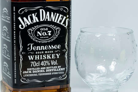 Close up of Jack Daniels whiskey bottle and glass placed next to it.のeditorial素材