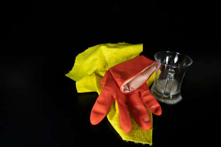 Scouring sponge foaming gloves and yellow cleaning cloth. In black background.の写真素材