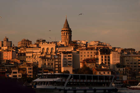 Istanbul, Turkey - November-02.2019: Galata tower and passenger ferry were photographed at golden hour at sunset.のeditorial素材