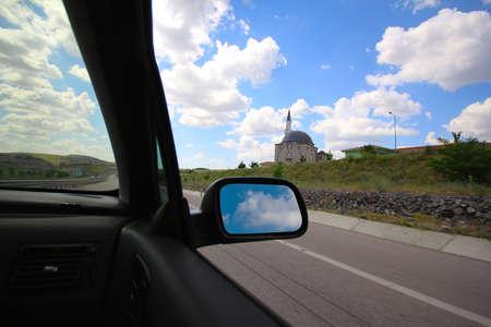 Asphalt road and cloudy blue sky from vehicle window. It was also taken during the journey in a sunny day.の写真素材