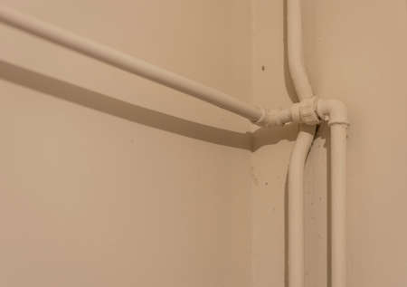 PVC hot water pipes installed in the corner of the wall are placed sloppy.