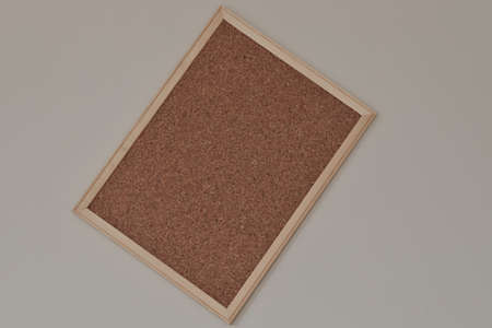 Cork board hanging on the wall with wooden frame. It is bent and about to fall.