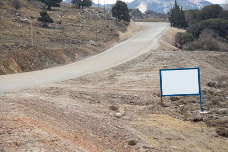 White curved advertising sign. Close-up. There are olive trees in the background. Photo taken in winter. Gokceada, Turkey.の写真素材