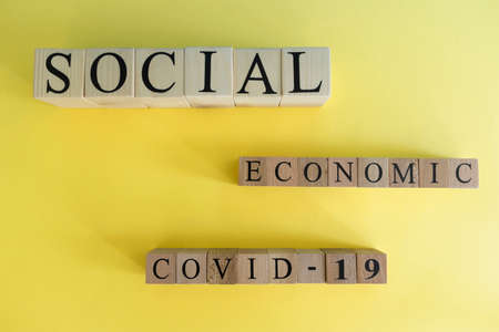 Economic, social and covid-19 text from wooden cube letters.の写真素材