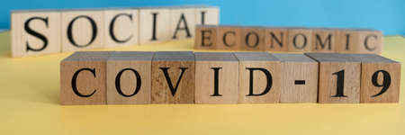 Economic, social and covid-19 text from wooden cube letters.の写真素材